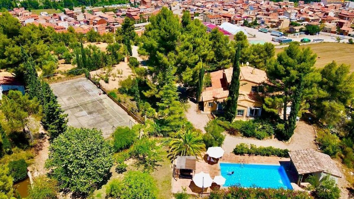 Imagen panorámica de la casa rural y el pueblo turolense de fondo