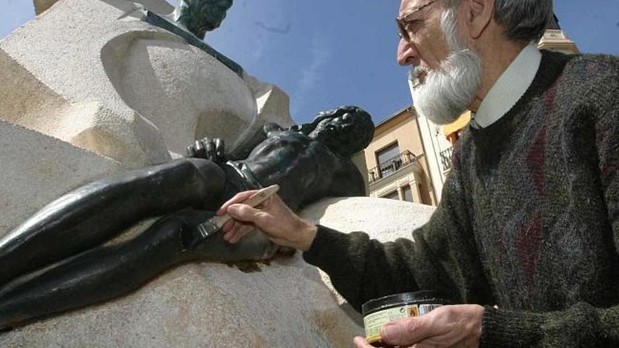 El escultor Hipólito Pérez Calvo limpia y encera el monumento a Ramón Álvarez.