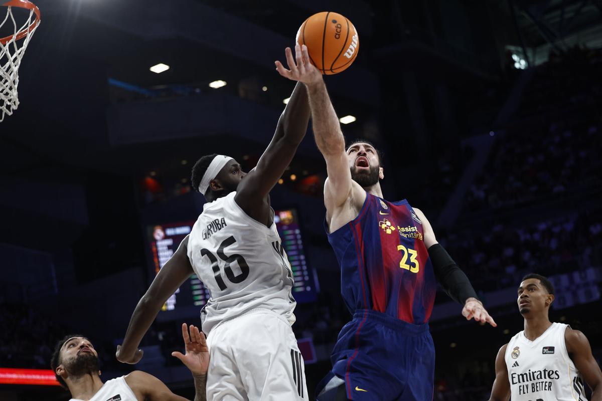MADRID (ESPAÑA), 04/01/2026.- El alero del Real Madrid Eli Ndiaye disputa un balón al pivot georgiano Tornike Shengelia (d) del FC Barcelona durante el partido de la ACB disputado entre el Real Madrid y el Barça este domingo en el Movistar Arena de Madrid EFE/ Daniel Gonzalez