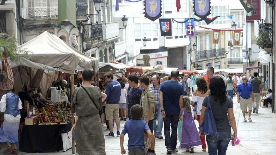Vecinos y visitantes miran los productos de los puestos de la Feria Medieval betanceira, el año pasado.