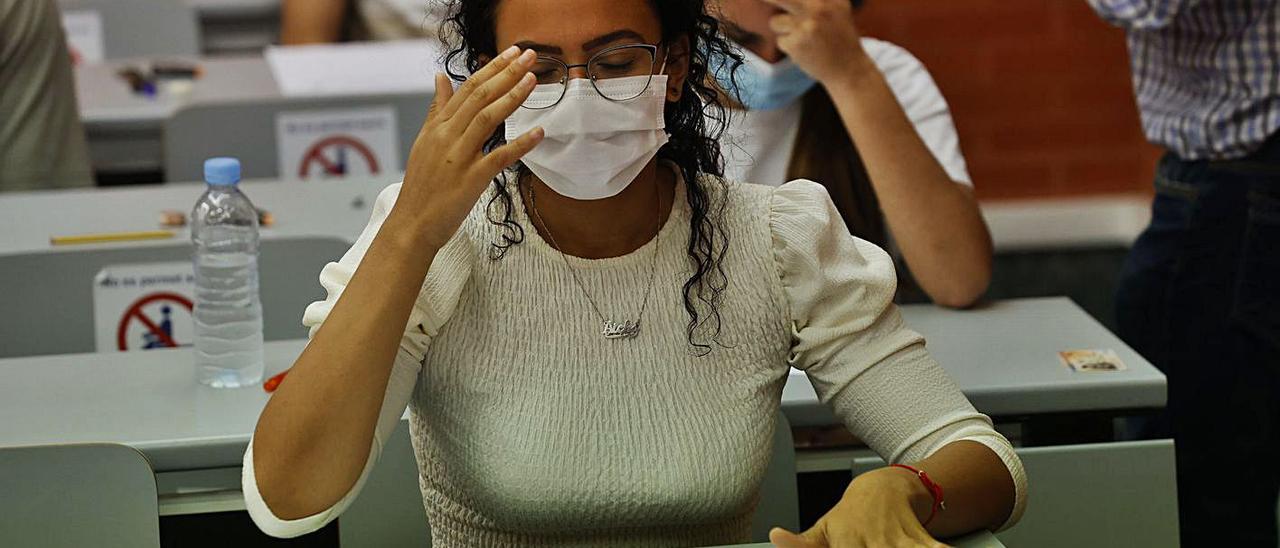 Una estudiante se lleva la mano a la cabeza al ver un examen en las últimas PAU en València. | GERMÁN CABALLERO