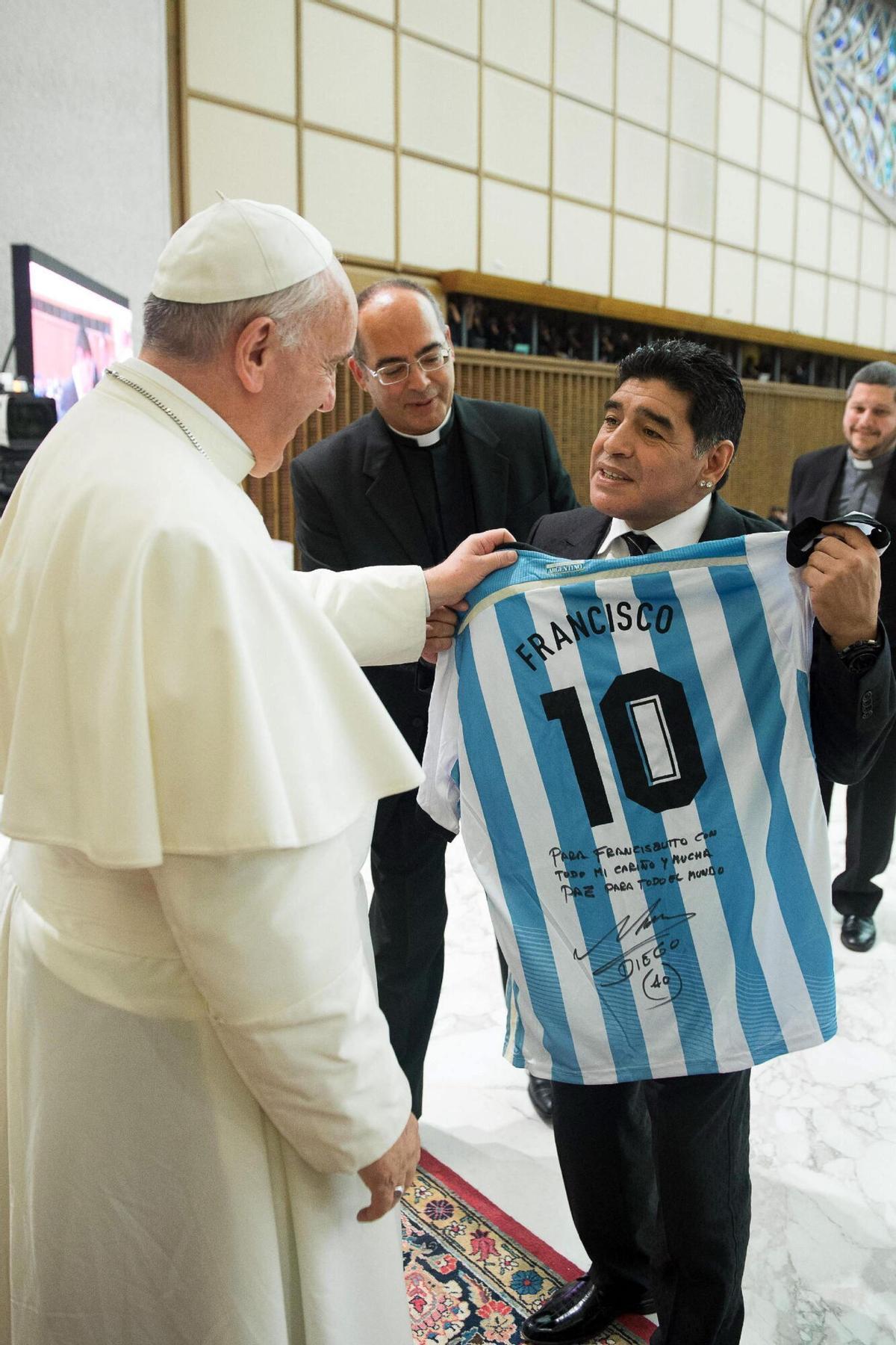 Maradona le entrega a Francisco la camiseta autografiada. | efeEn las fotos pequeñas, el encuentro del Papa y Maradona. | efeVAT07 CIUDAD DEL VATICANO (VATICANO), 01/09/2014.- Fotografía facilitada por el diario vaticano LOsservatore Romano del exfutbolista argentino Diego Armando Maradona (d) entregando una camiseta de la selección argentina de fútbol al papa Francisco (i) durante su encuentro en el Vaticano hoy, lunes 1 de septiembre de 2014. Maradona participará en el Partido por la Paz que se jugará hoy en Roma, Italia. El Partido por la Paz, el primero de estas características, es una iniciativa organizada por Scholas Occurrentes y la Fundación PUPI italiana, fundada por el ex jugador argentino Javier Zanetti. EFE/LOsservatore Romano / SÓLO USO EDITORIAL/PROHIBIDA SU VENTA MARADONA EN EL VATICANO. SOLO USO EDITORIAL/PROHIBIDA SU VENTA