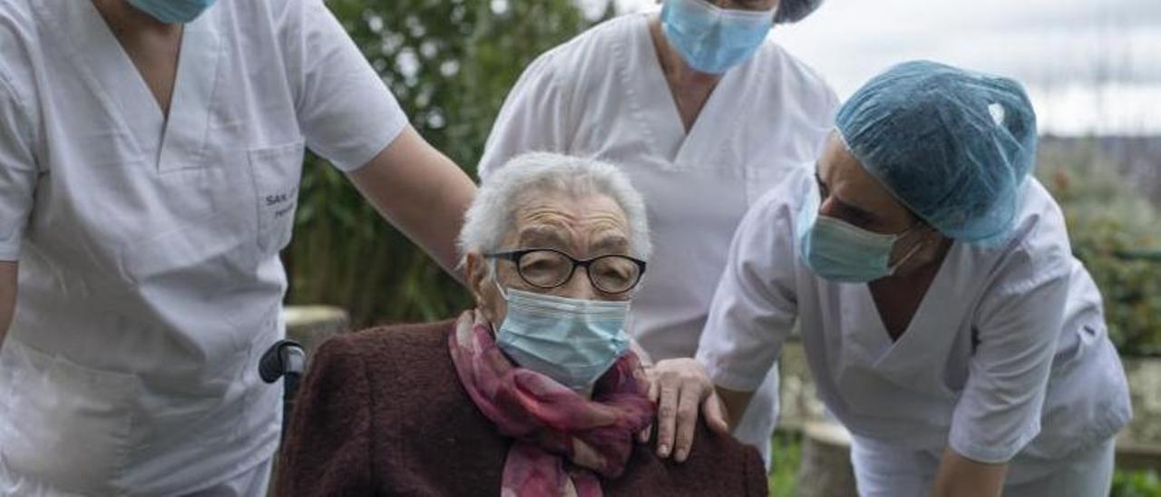 Elena Pérez, este fin de semana, en el patio exterior de la residencia San Carlos de Celanova, acompañada de las cuidadoras.   | //  BRAIS LORENZO