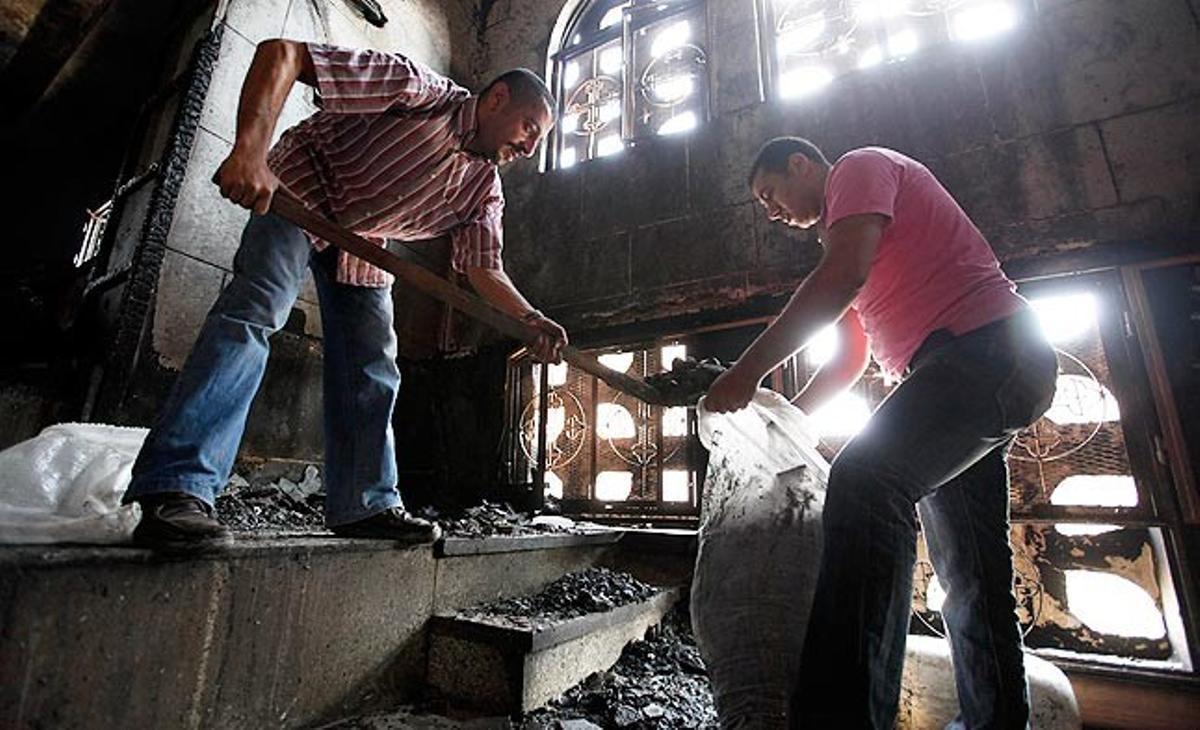 Uns homes recullen aquest diumenge runa a l’església de Santa Maria, al Caire. Aquest diumenge, uns enfrontaments entre musulmans i cristians al barri d’Imbamba ha acabat amb deu morts. Ha passat després que unes dones cristianes es convertissin a l’Islam.