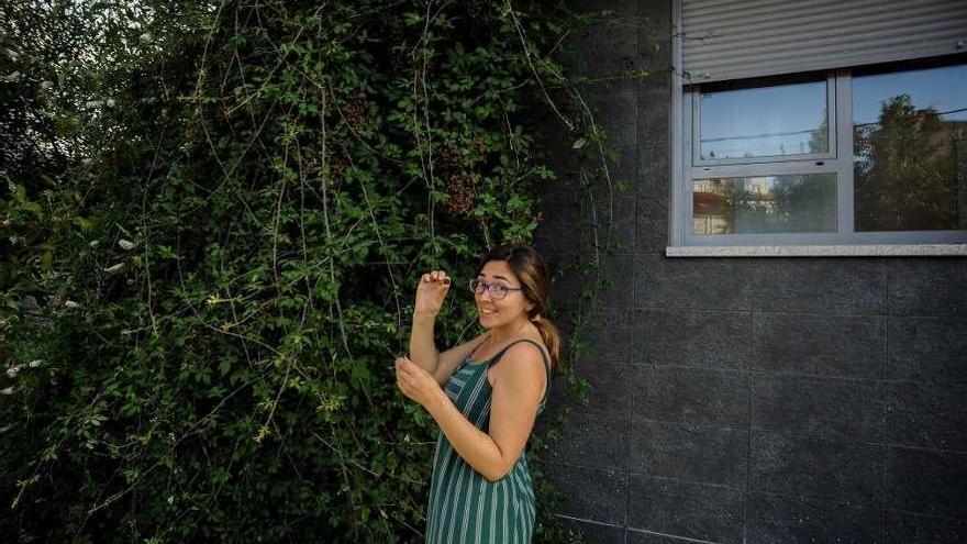 Lara González, junto a las zarzas que están a punto de tapar una de las ventanas de su casa. // Iñaki Abella