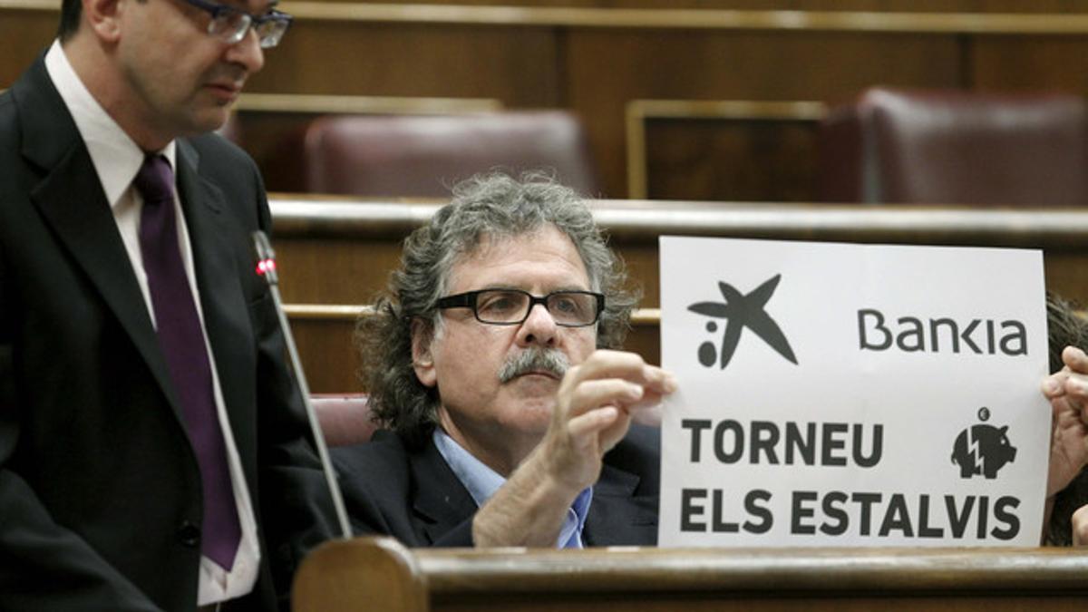 Joan Tardà exhibe un cartel contra las participaciones preferentes, en el Congreso.