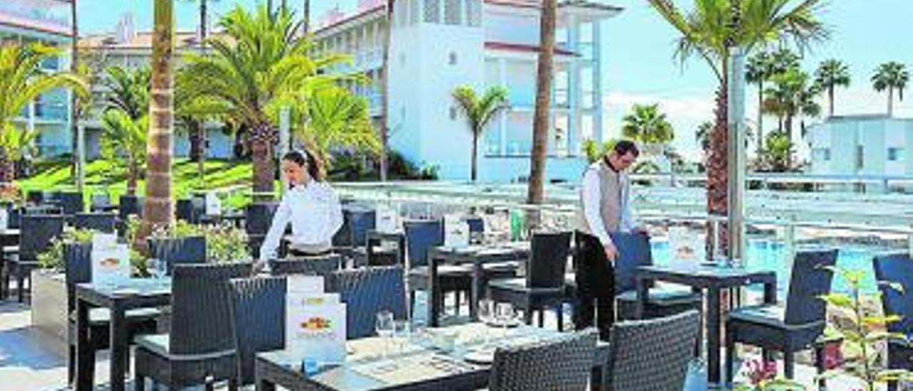 Dos camareros preparan la terraza del RIU Arecas, en Costa Adeje. | | LP/DLP