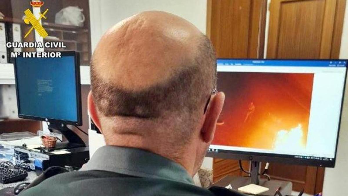 Un agente analizando las imagenes de la quema de contenedores.