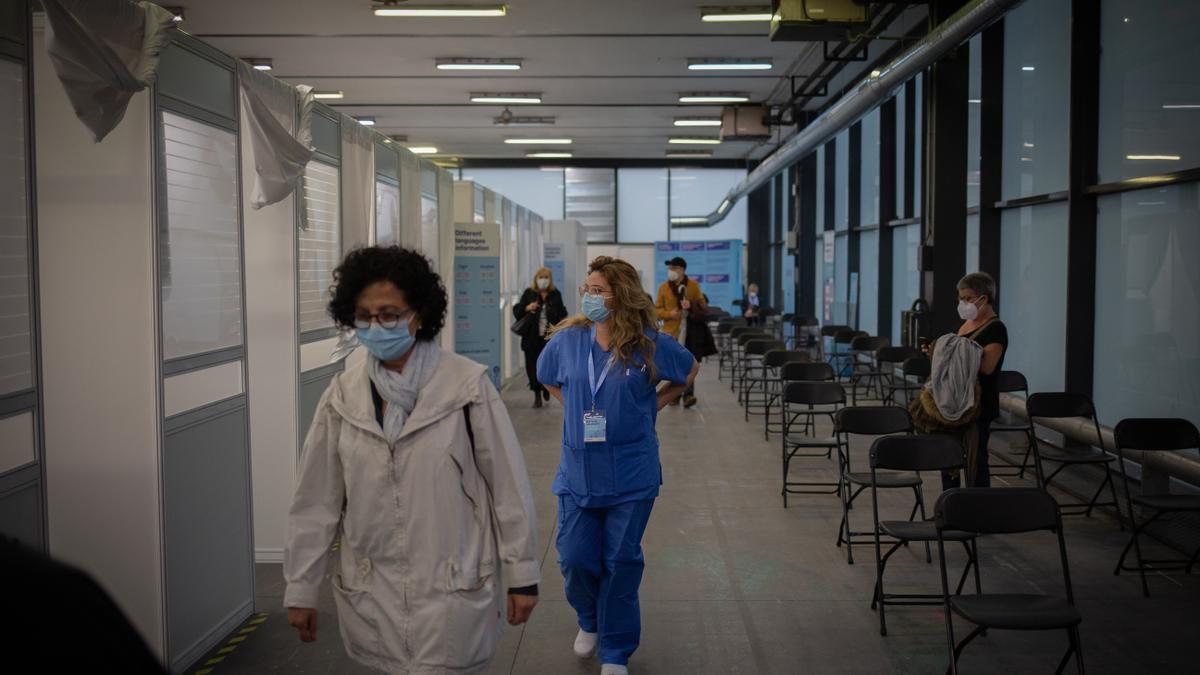 Una  dona i una sanitària en el circuit de vacunació de Fira de Barcelona.