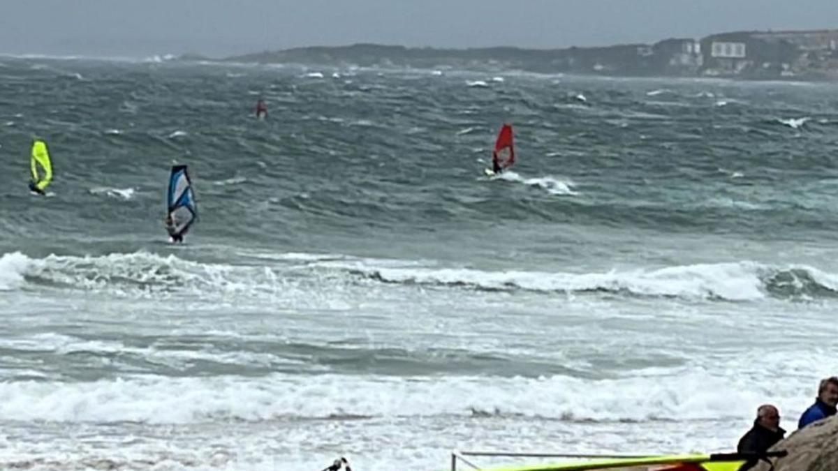 Varios windsurfistas cabalgan sobre las olas en O Grove.   | // FDV 