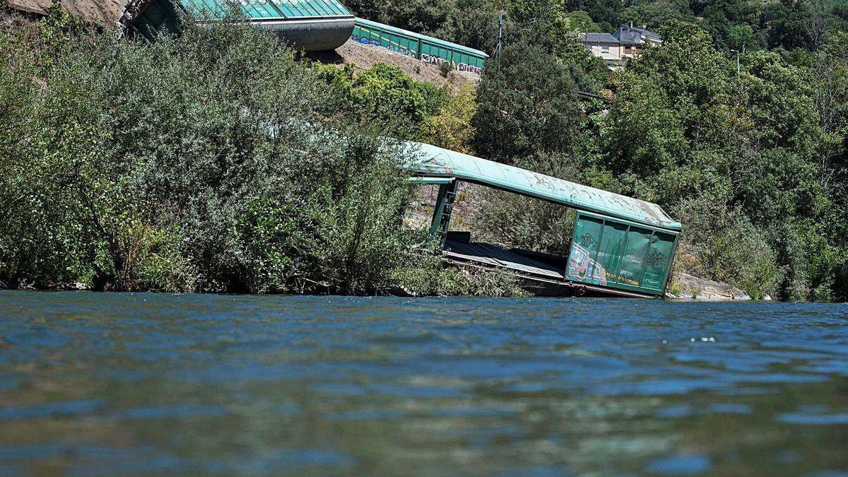 Los dos vagones del tren de mercancías siniestrado arrojados al cauce del Sil.