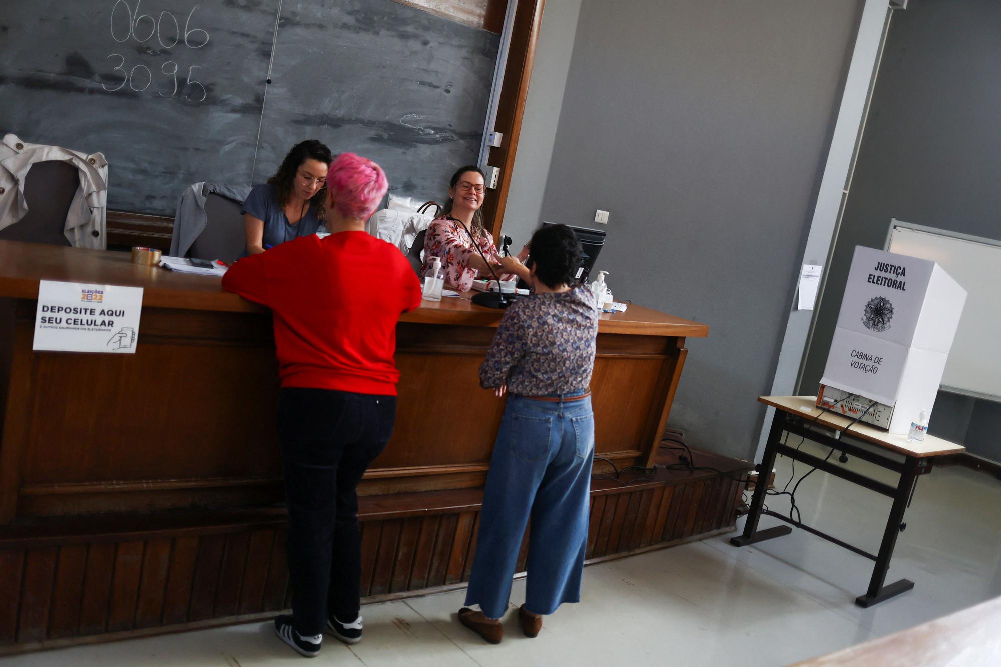 Citizens of Brazil present their identification to cast their votes for their country's election, in Lisbon