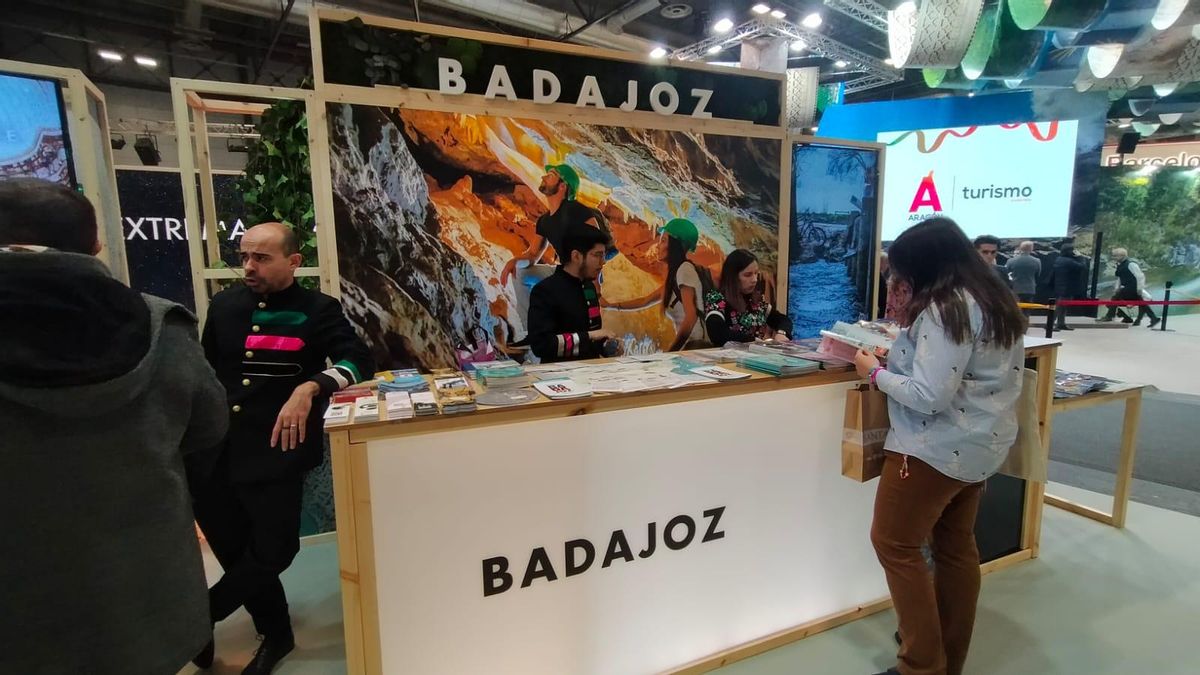 El mostrador de Badajoz en el estand de Extremadura de Fitur, con una fotofrafía de unos escaladores.