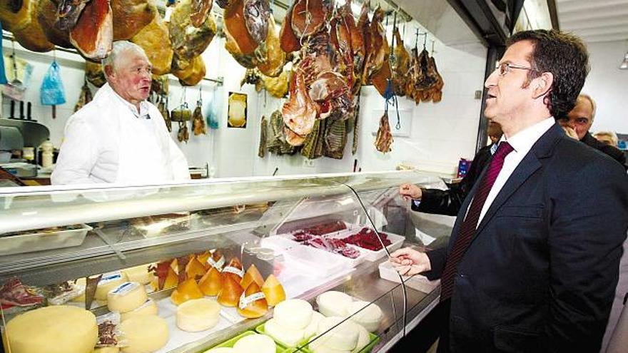 Alberto Núñez Feijóo charla con un carnicero en una de sus visitas al mercado durante la pasada campaña electoral. / la opinión