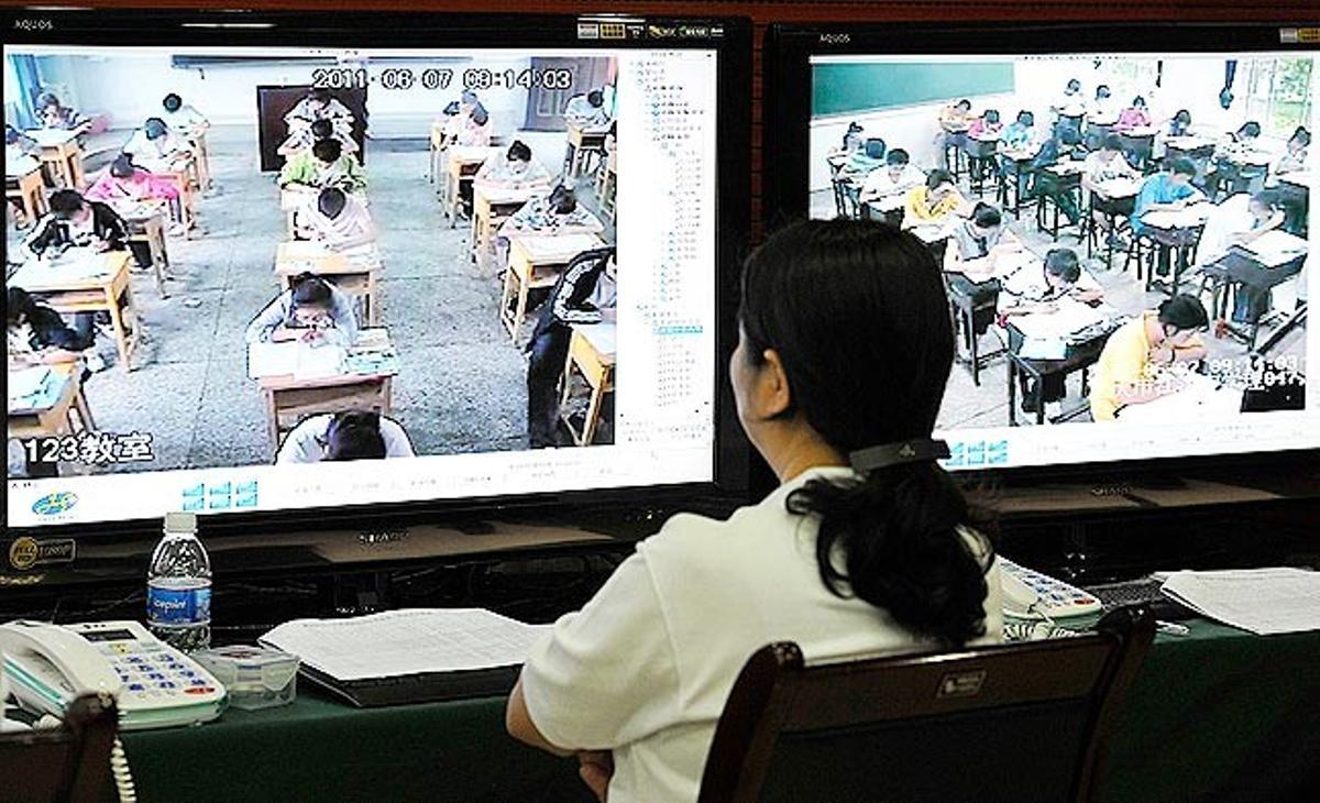 Una empleada china de un centro de exámenes vigila mediante cámaras a un grupo de estudiantes durante las pruebas de selectividad de este martes en la ciudad de Chongqing. Unos nueve millones de estudiantes chinos harán esta prueba entre el 7 y el 8 de junio.