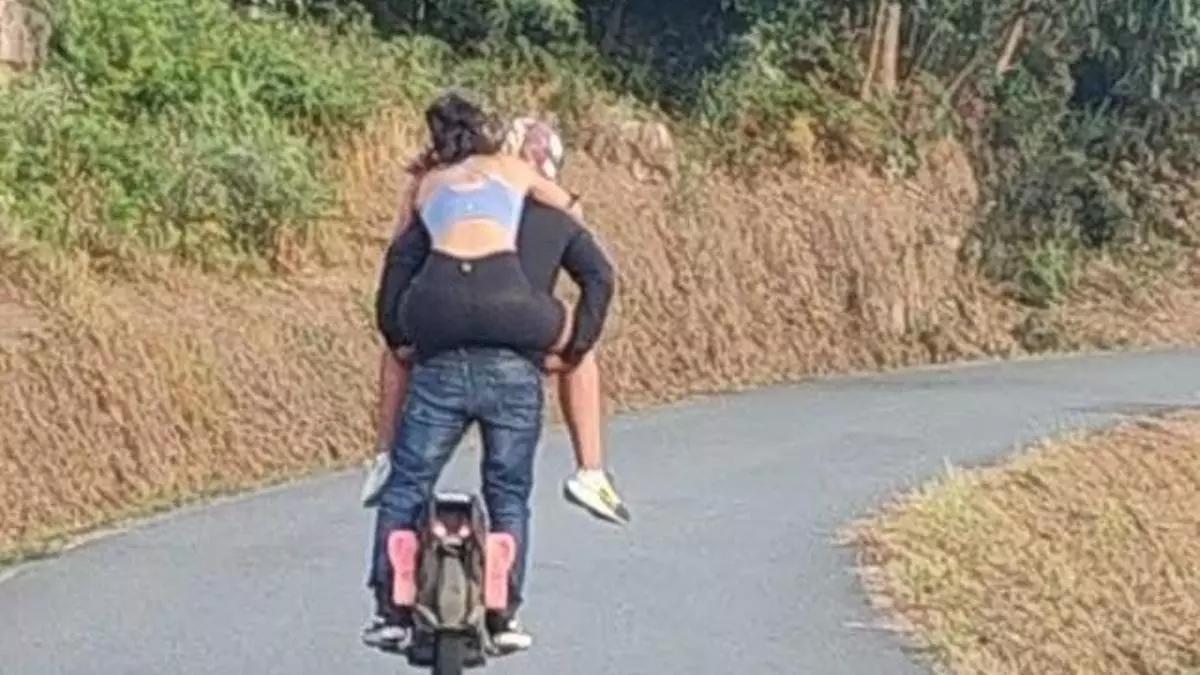 Circula por Arteixo en un monociclo eléctrico con una mujer a hombros