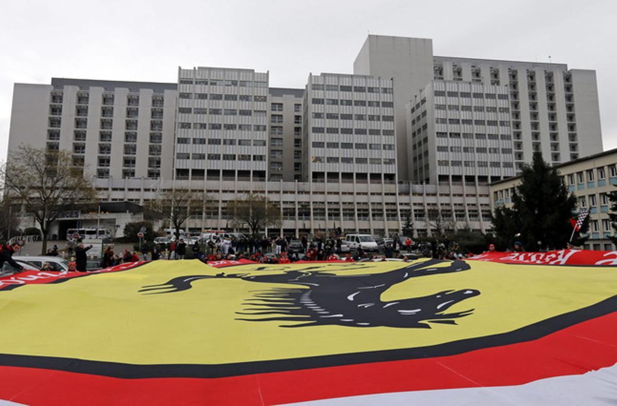 Seguidors de Schumacher despleguen una bandera gegant de Ferrari davant de l’hospital de Grenoble, aquest divendres.