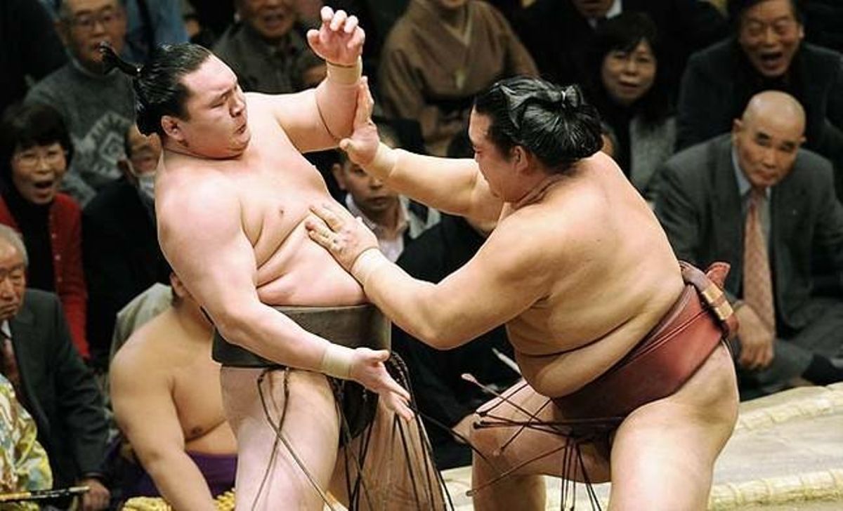 El campió de sumo Hakuho, esquerra, tracta d’aguantar la càrrega de Kisenosato al límit del ring durant el seu combat del Gran Torneig de Sumo d’Any Nou, a Tòquio.