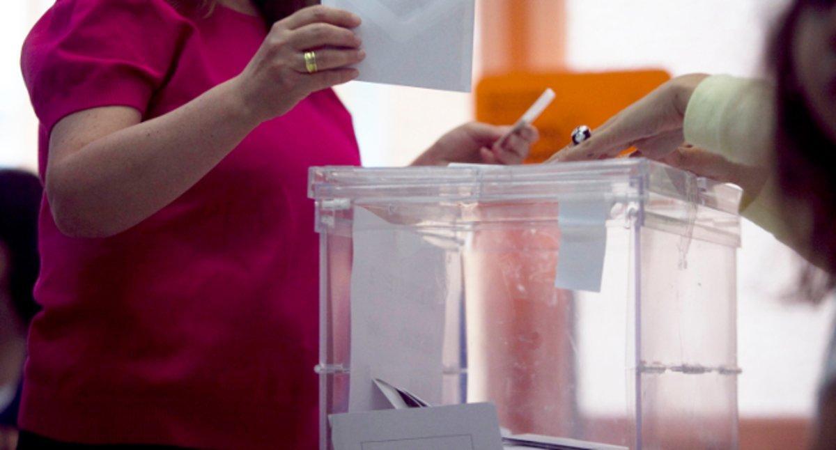 Una electora deposita su voto en la urna.