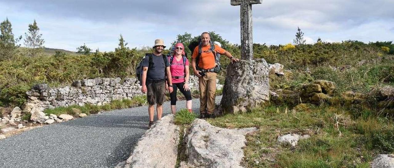 Los tres peregrinos lusos que ayer llegaron a Codeseda, junto a la Cruz de A Grela. // Codeseda Viva