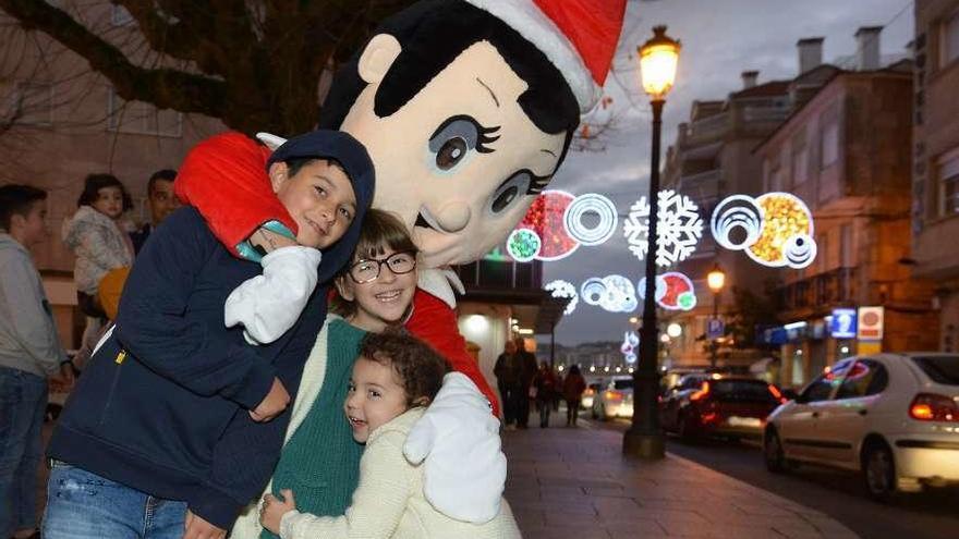 Arriba, el &quot;Trasno&quot; que se paseó ayer por las calles de Sanxenxo y a la izquierda, algunas de las luces navideñas. // G. Santos