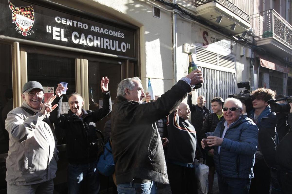 Un grupo de personas celebran haber sido agraciados con el número 26590 el Gordo de Navidad, que ha sido vendido, entre otros lugares, en el Centro Aragonés Cachirulo de Reus (Tarragona).