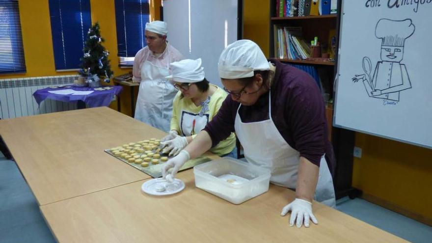 Usuarios del CAI Penlés adornando la última hornada de galletas.