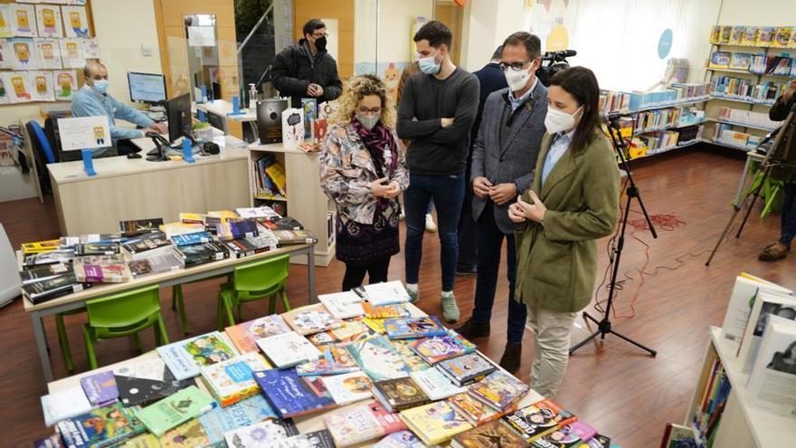 La delegada visita la biblioteca con el alcalde.