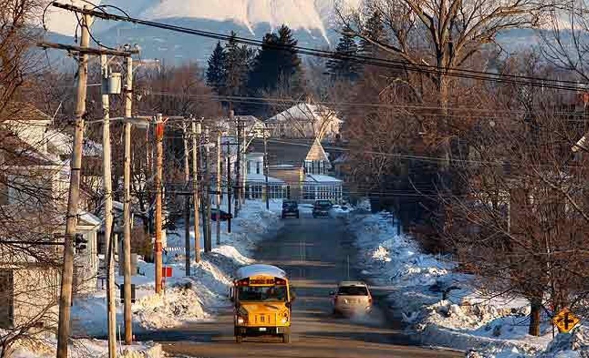 Davant l’exultant muntanya Katahdin, un autobús escolar realitza la seva ruta a la població de Millinocket (Maine, Estats Units). Amb objecte d’atraure estudiants estrangers, l’institut públic de la ciutat promociona els recursos naturals de l’entorn.