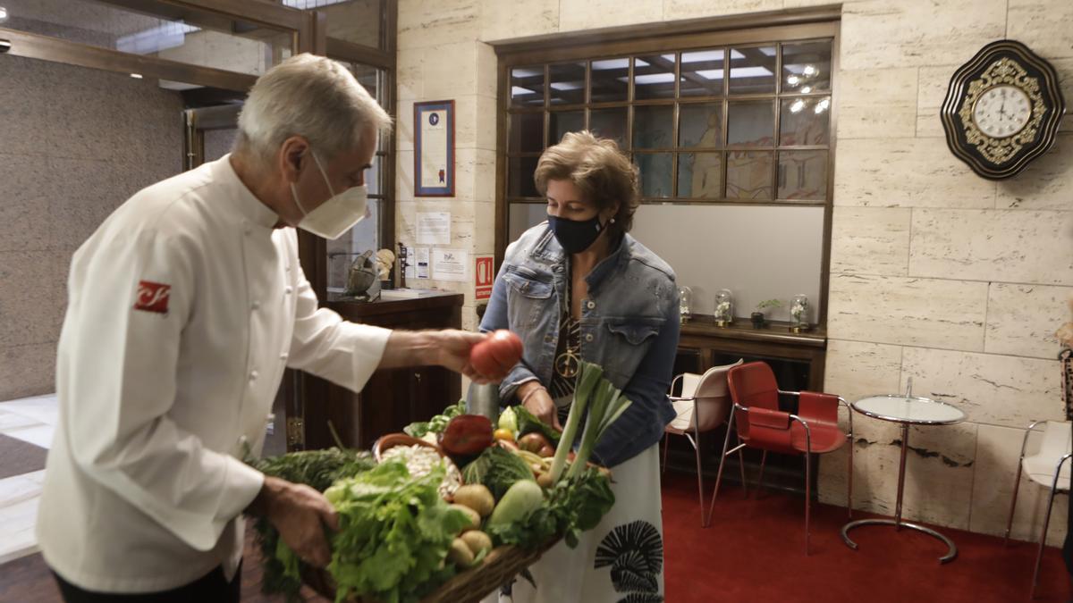 Luis Alberto Martínez revisa un tomate, ante la mirada de Balbina Álvarez.