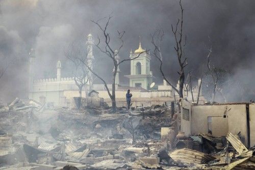Un hombre permanece en frente de una mezquita en llamas en Meikhtila (Myanmar)
