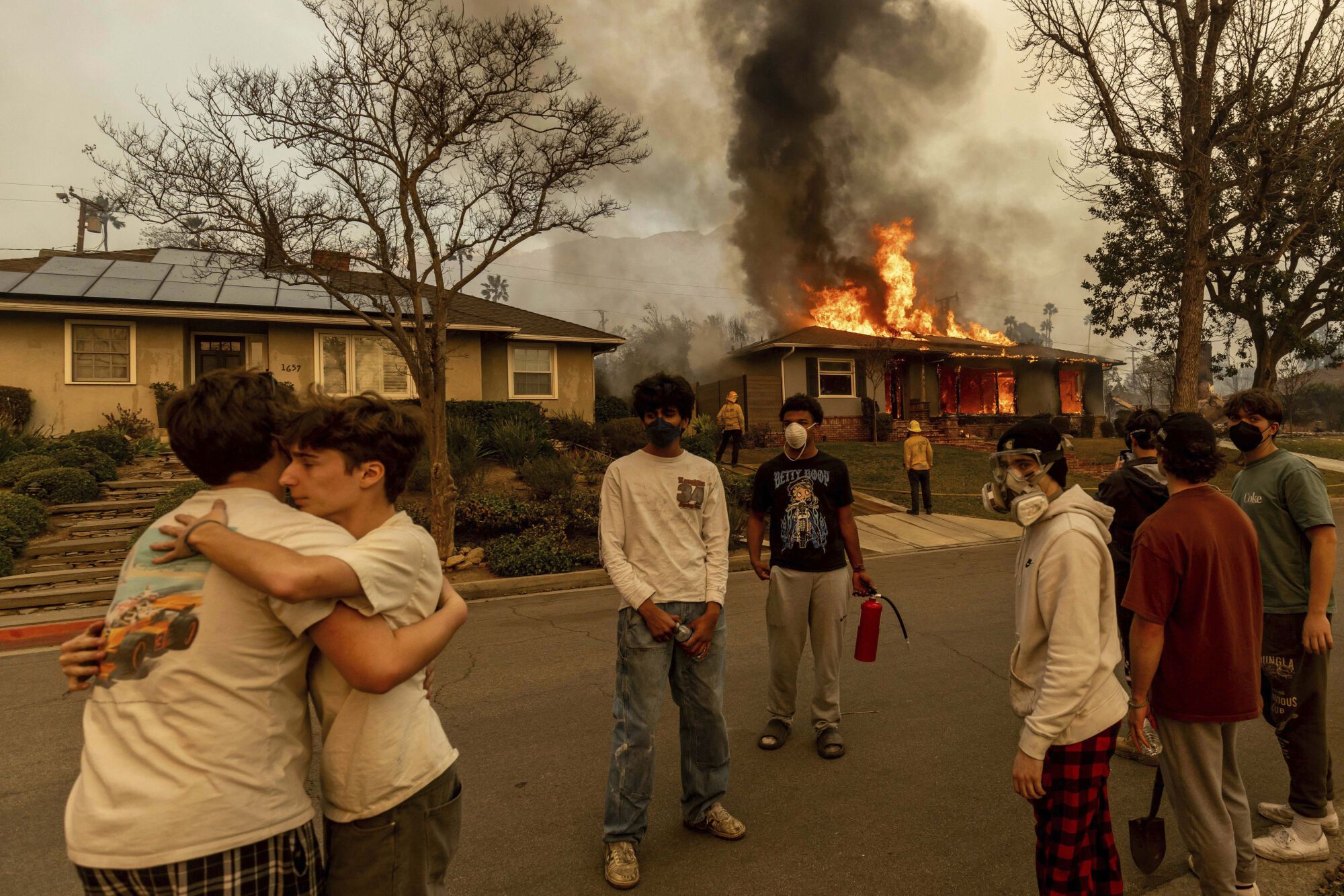 Residents embrace outside of a burning property as the Eaton Fire swept through Wednesday, Jan. 8, 2025 in Altadena, Calif. (AP Photo/Ethan Swope) associated Press / LaPresse Only italy and Spain. EDITORIAL USE ONLY/ONLY ITALY AND SPAIN