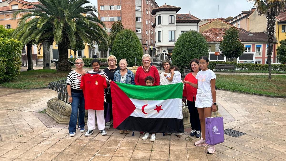 Por la izquierda, Patricia Redondo, Chirifa Emhamed, Pilar Cuesta, Amparo Antuña, Belén Cueva, Héctor Cabeza, Laura García, Carla Cabeza, María Luisa Fonseca y Hana Matala, con una bandera saharaui, en la plaza del Ayuntamiento de Noreña.