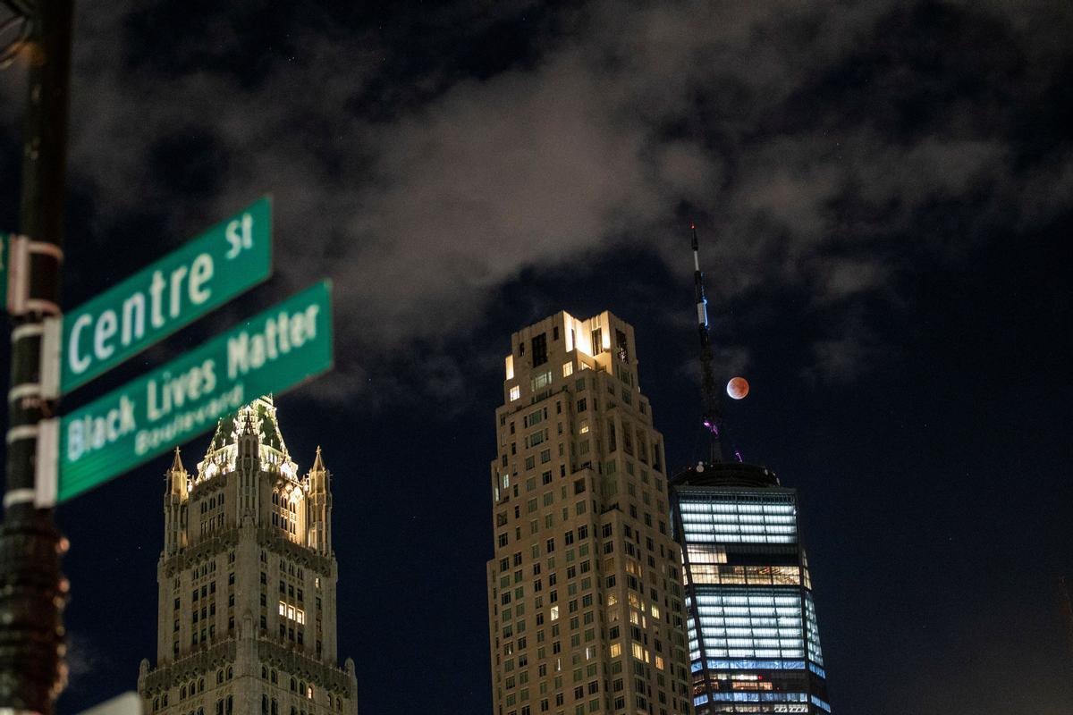 La luna, durante el eclipse parcial, vista cerca del One World Trade Center de Nueva York.