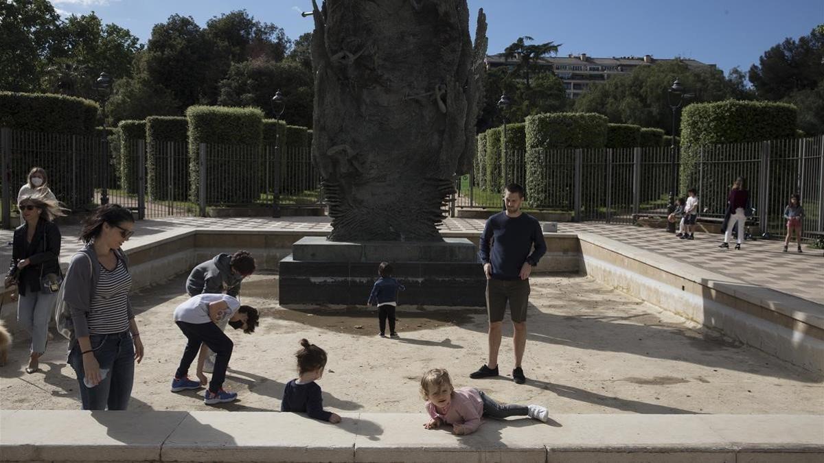 Unos niños juegan ante el Turó Park de Barcelona.