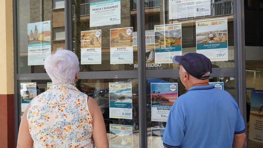 Dos personas miran las ofertas en una agencia de viajes de la capital.