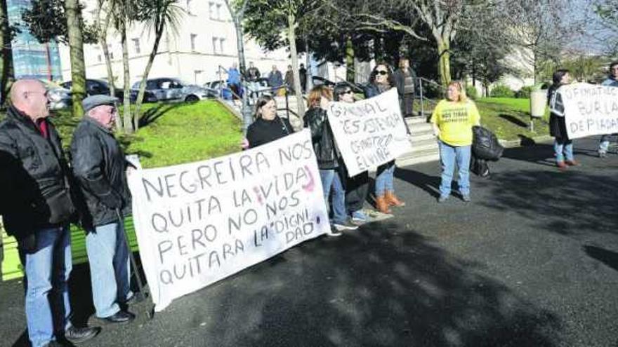 Los residentes en el ofimático, concentrados con pancartas ante el centro cívico de Palavea durante la visita del alcalde. / 13fotos