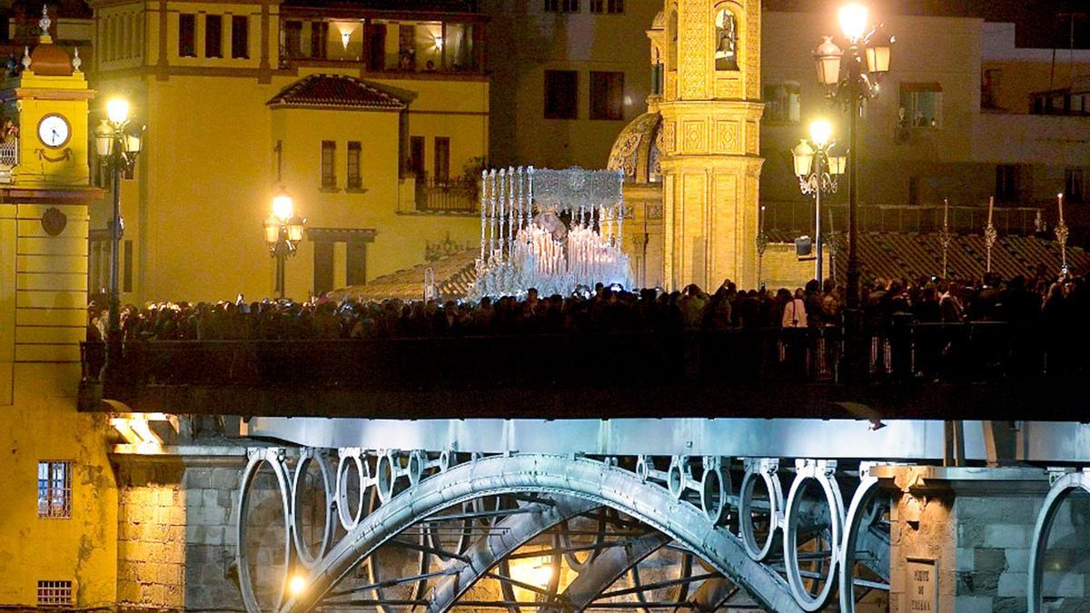 La Virgen de la Esperanza de Triana, a la salida de la capilla de los Marineros para iniciar su procesión en la celebración de la Madrugá sevillana.