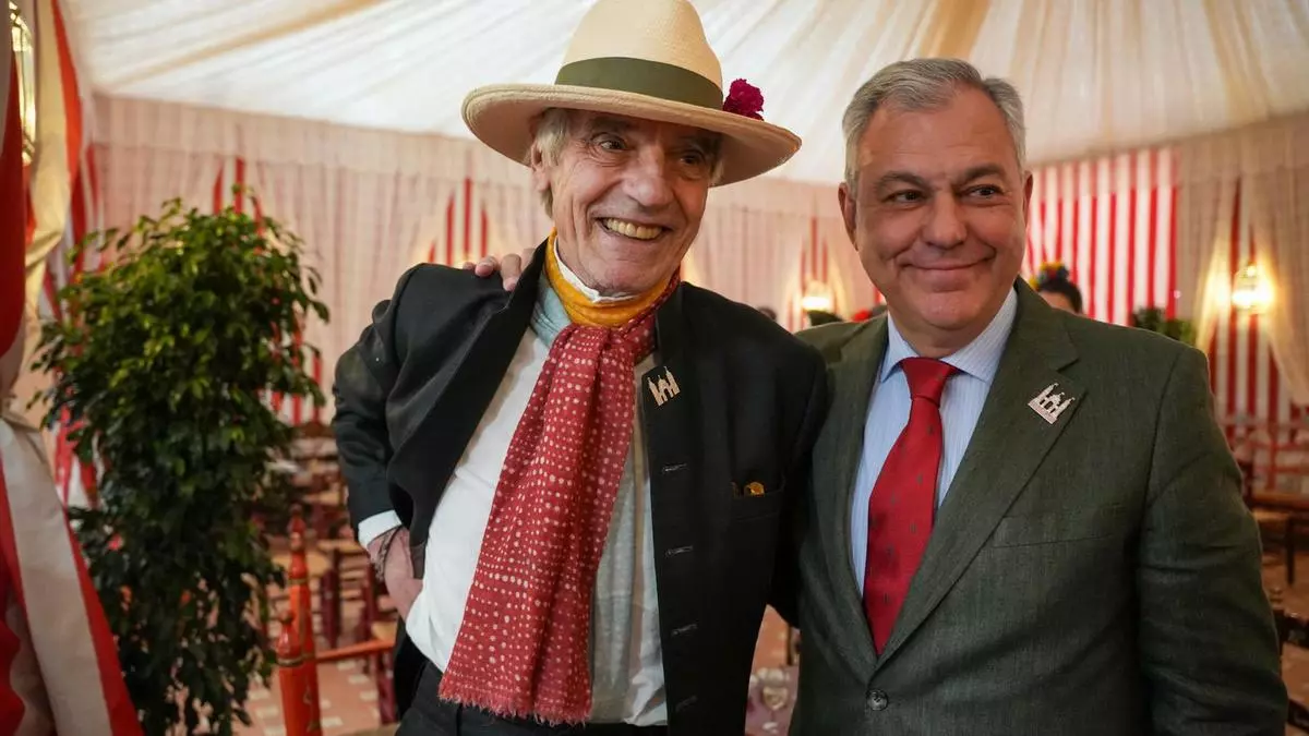 Jeremy Irons cumple con las tradiciones de la Feria de Sevilla: pin de la portada, rebujito y jamón