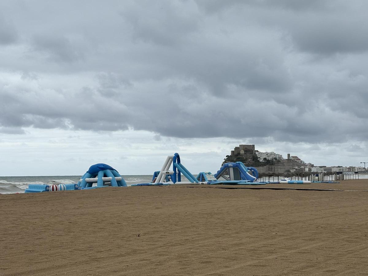 El hinchable acuático, sobre la arena, con el castillo al fondo.