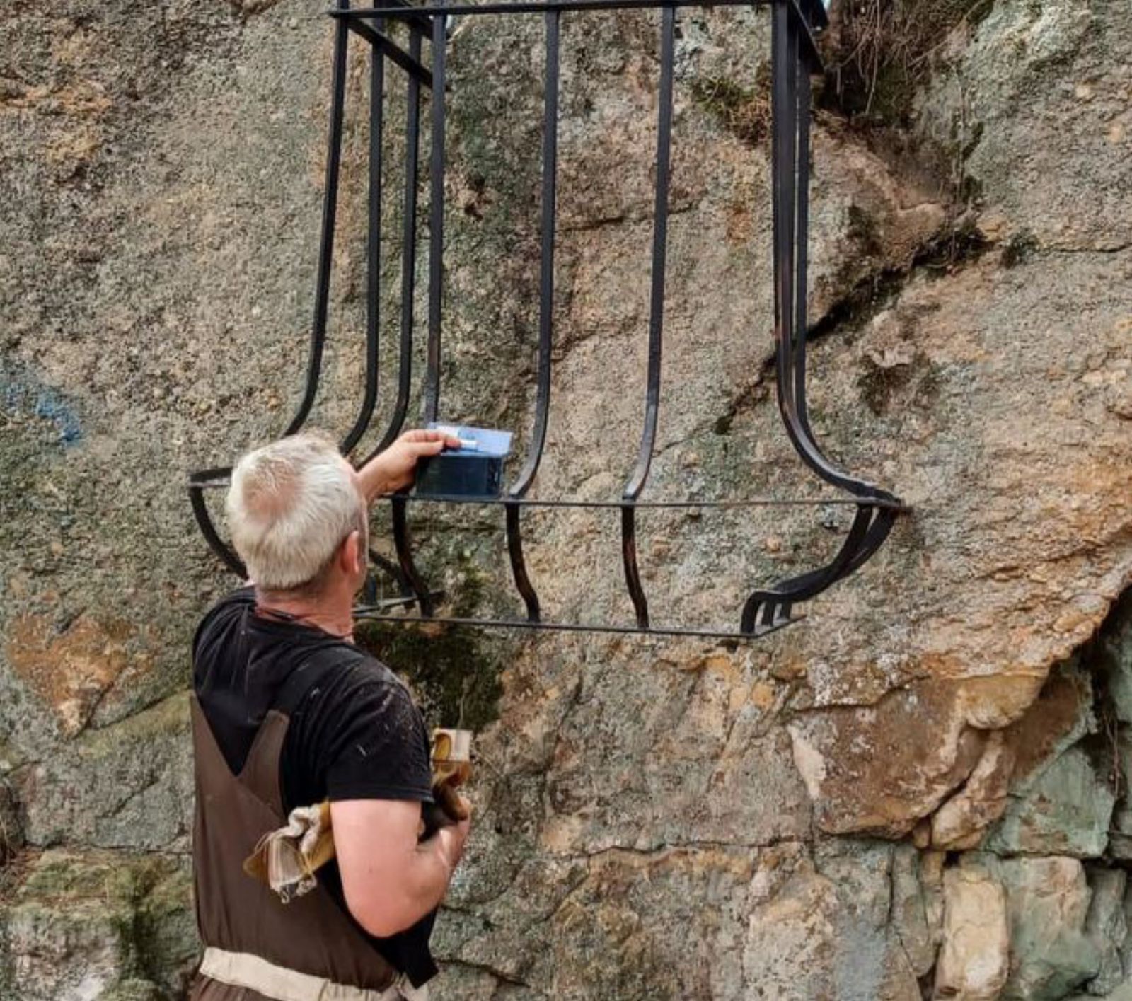 Un balcón de forja adherido a la piedra.