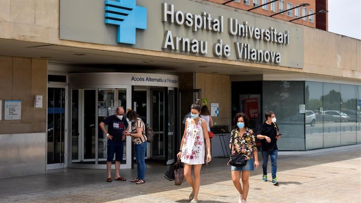 Gente con mascarilla sale del Hospital Arnau de Vilanova, en Lleida