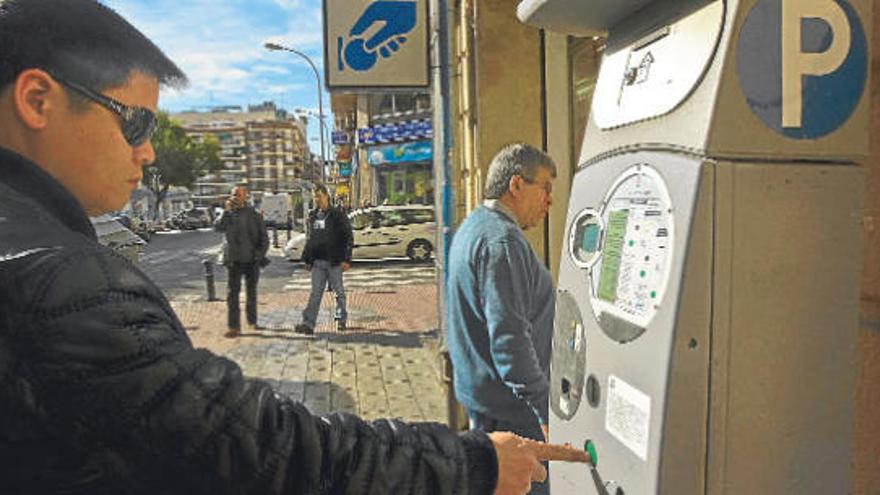 Un joven solicita un ticket en una de las máquinas expendedoras del centro de la ciudad de Alicante