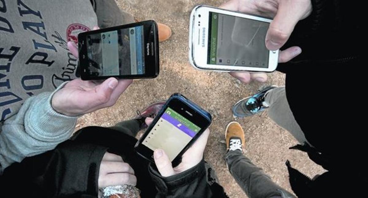Un grup d’adolescents manipulen l’aplicació Snapchat al mòbil, ahir, a Barcelona.