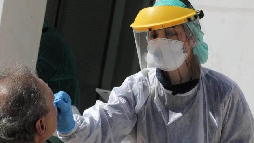 Profesionales de Madrid Salud, protegidos con batas, máscaras y guantes, efectúan pruebas para detectar el coronavirus.