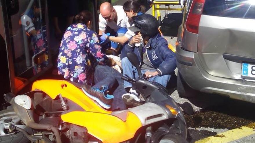 Los servicios sanitarios atienden al acompañante del piloto de la moto accidentada. // FDV