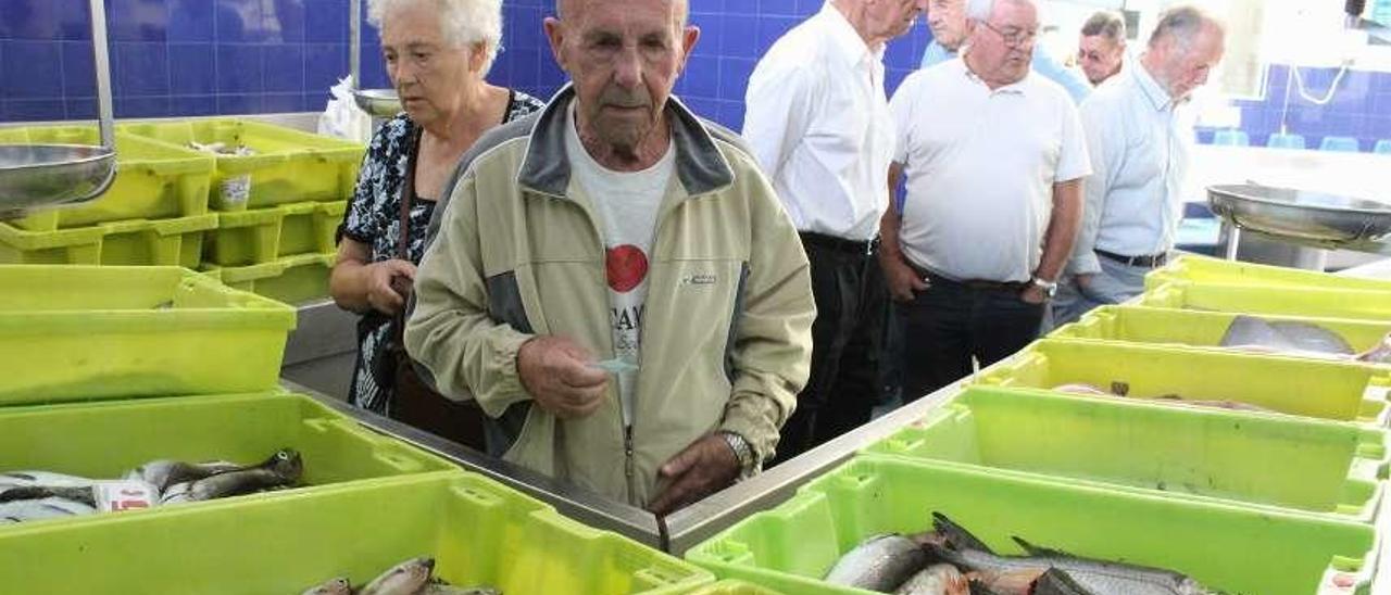 Agustín Rodríguez, en primer término, comprando pescado en la rula de Candás.