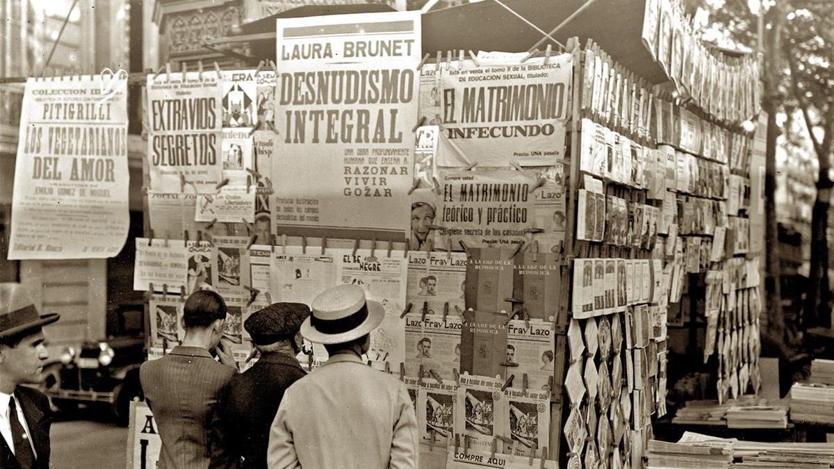 Lectura de diarios y revistas en un quiosco de las Ramblas hace un siglo.