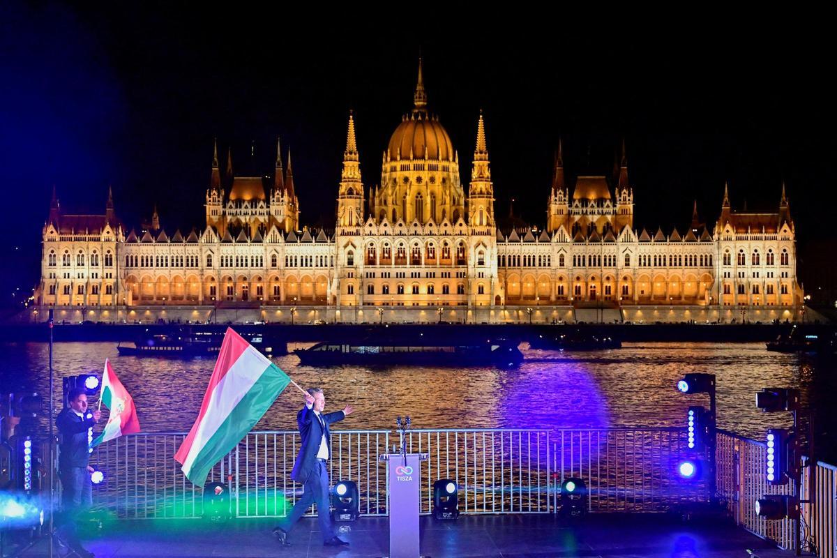 Peter Magyar, líder del partido opositor Tisza, sostiene una bandera nacional tras conocerse los resultados parciales de las elecciones parlamentarias en Budapest, Hungría, el 12 de abril de 2026