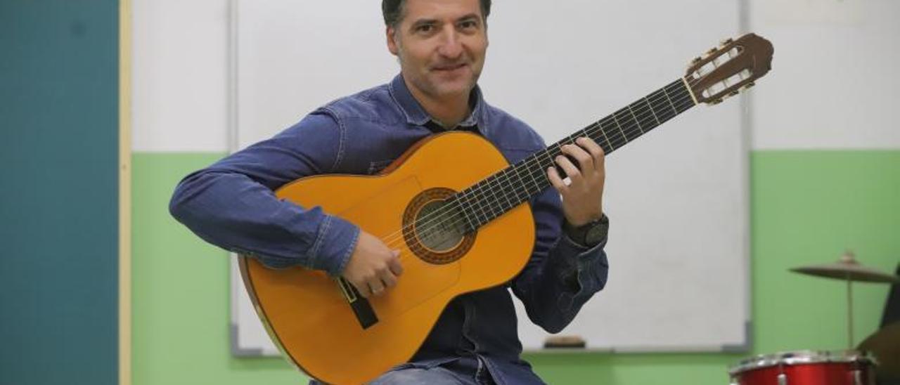 Guillermo Salinas posa, con su guitarra, en el CEIP Algafequi.